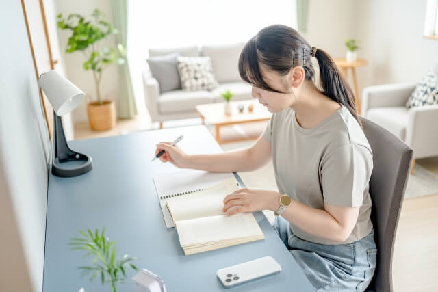 ノートに記録を書く女性