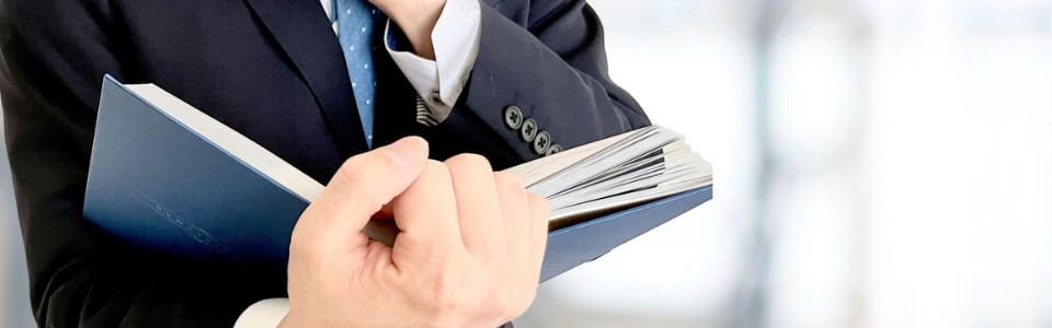 本を手に取るビジネスパーソン